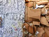 stack of shredded old waste paper and cardboard in front of recycling facility