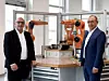 Wolfgang Mayer (CTO) und Abdullah Cevik (CPO) von Kuka vor Robotern des Unternehmens