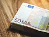 Ein Stapel 50-Euro-Scheine liegt auf einem Holztisch