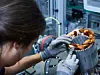 Eine Monteurin bei BMW setzt Teile eines Elektroautos zusammen