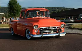 Old american chevrolet pickup truck on the road. Vintage car orange truck - retro style.