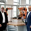 Wolfgang Mayer (CTO) und Abdullah Cevik (CPO) von Kuka vor Robotern des Unternehmens