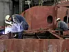 Welders with protective mask welding metal at double bottom ship in a shipyard