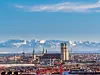Luftaufahme von München mit Marienkirche, im Hintergrund die schneebedeckten Berge, blauer Himmel