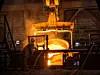 Steelworker at work near the tanks with hot metal