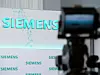 Siemens Logo auf Pressekonferenz. Im Vordergrund eine Fernsehkamera