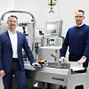 Frank Osterhagen und Thomas Schoen von Bizerba stehen an einer Maschine