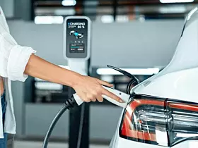 Young woman travel with EV electric car to shopping center parking lot innards
