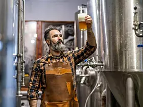 Mann prüft ein frisch gebrautes Bier