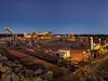 Bulldozer loading rocks into the crusher within the copper mine head at dusk in NSW Australia