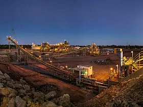 Bulldozer loading rocks into the crusher within the copper mine head at dusk in NSW Australia