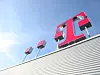 Logo der Telekom in magenta auf Hausdach bei schönem Wetter