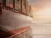 Ein Containerschiff fährt in den Sonnenuntergang
