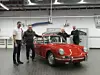 Restaurierter Porsche 901 im Porsche Museum mit zwei Mitarbeitern des Museums, dem Vorbesitzer und dem Trödeltrupp-Moderator