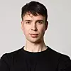 Porträt eines jungen Mannes mit dunklem Haar vor grauem Hintergrund. Vladimir Keil, Co-Founder & CEO von Lio Technologies